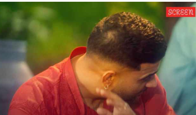 Karan Aujla performing on stage with a microphone, exuding confidence and passion.